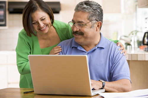 Senior couple using laptop in the kitchen